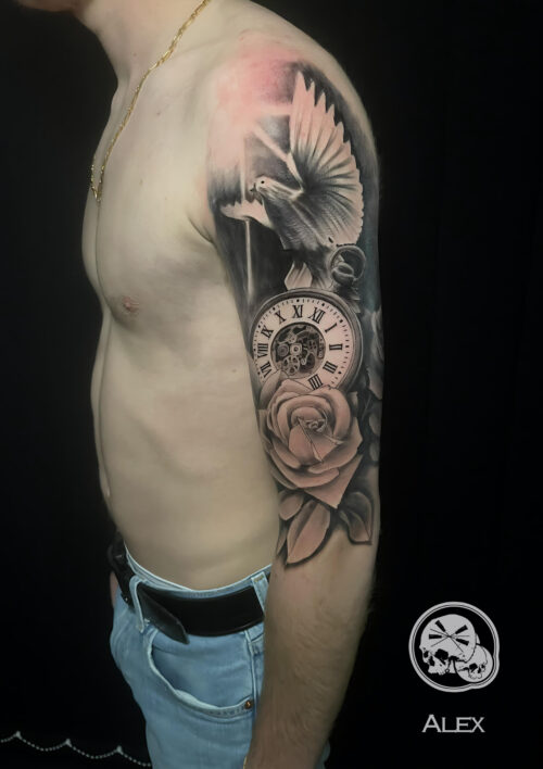 Haut de bras tatouer avec une colombe une montre à gousset et une rose